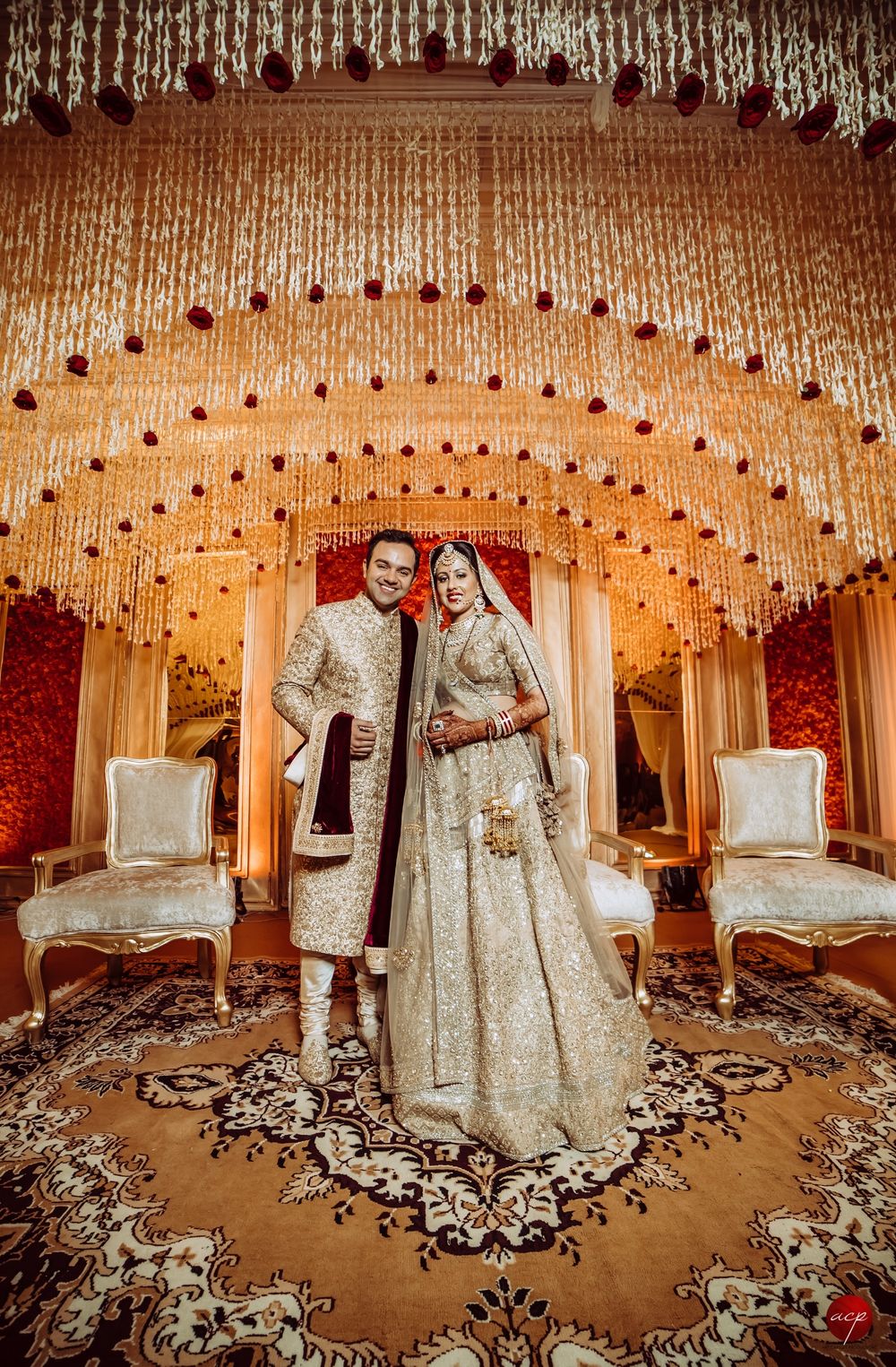 Photo of Grand wedding decor with bride and groom in gold