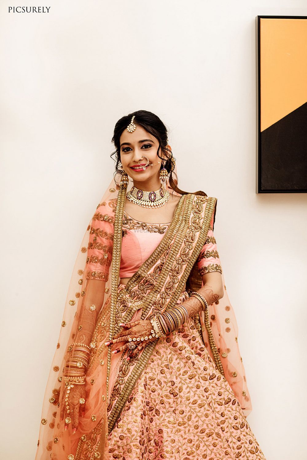 Photo of A bride in pink lehenga and scalloped dupatta