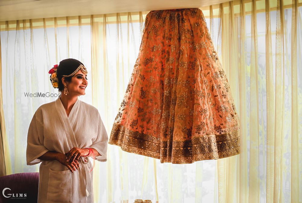 Photo of Bride with lehenga on the hanger while getting ready