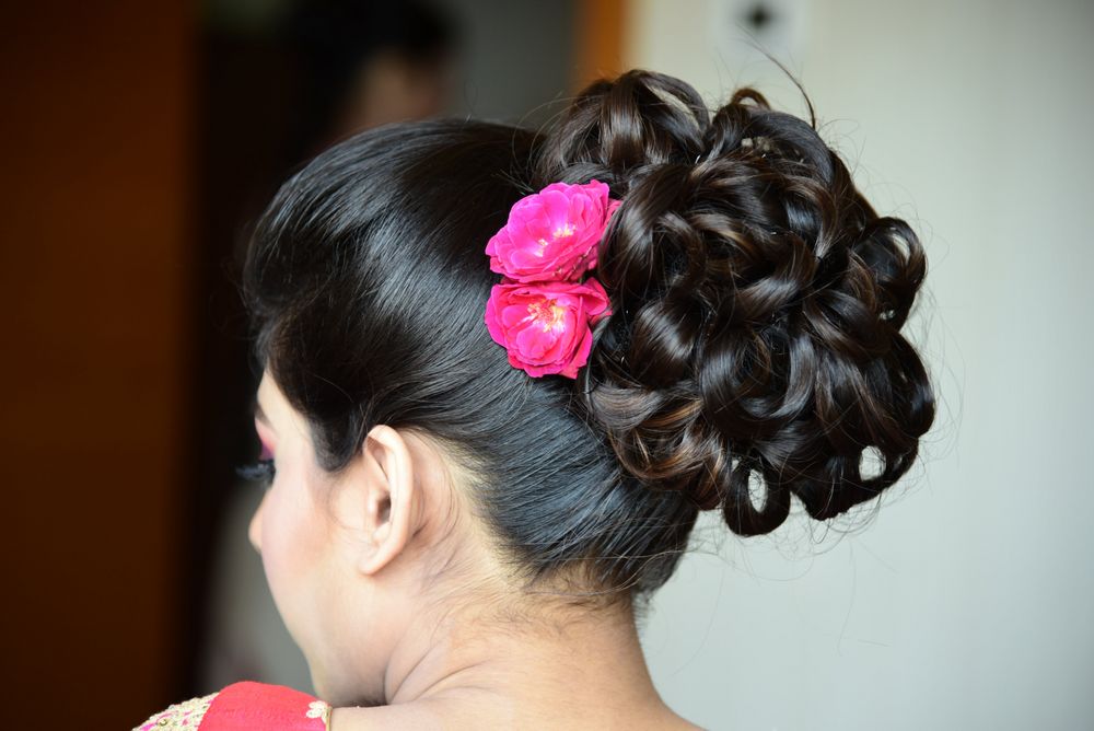 Photo of Wavy Hair Bun with Pink Flowers in Hair