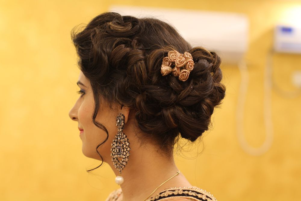 Photo of Braided bun with gold cloth roses