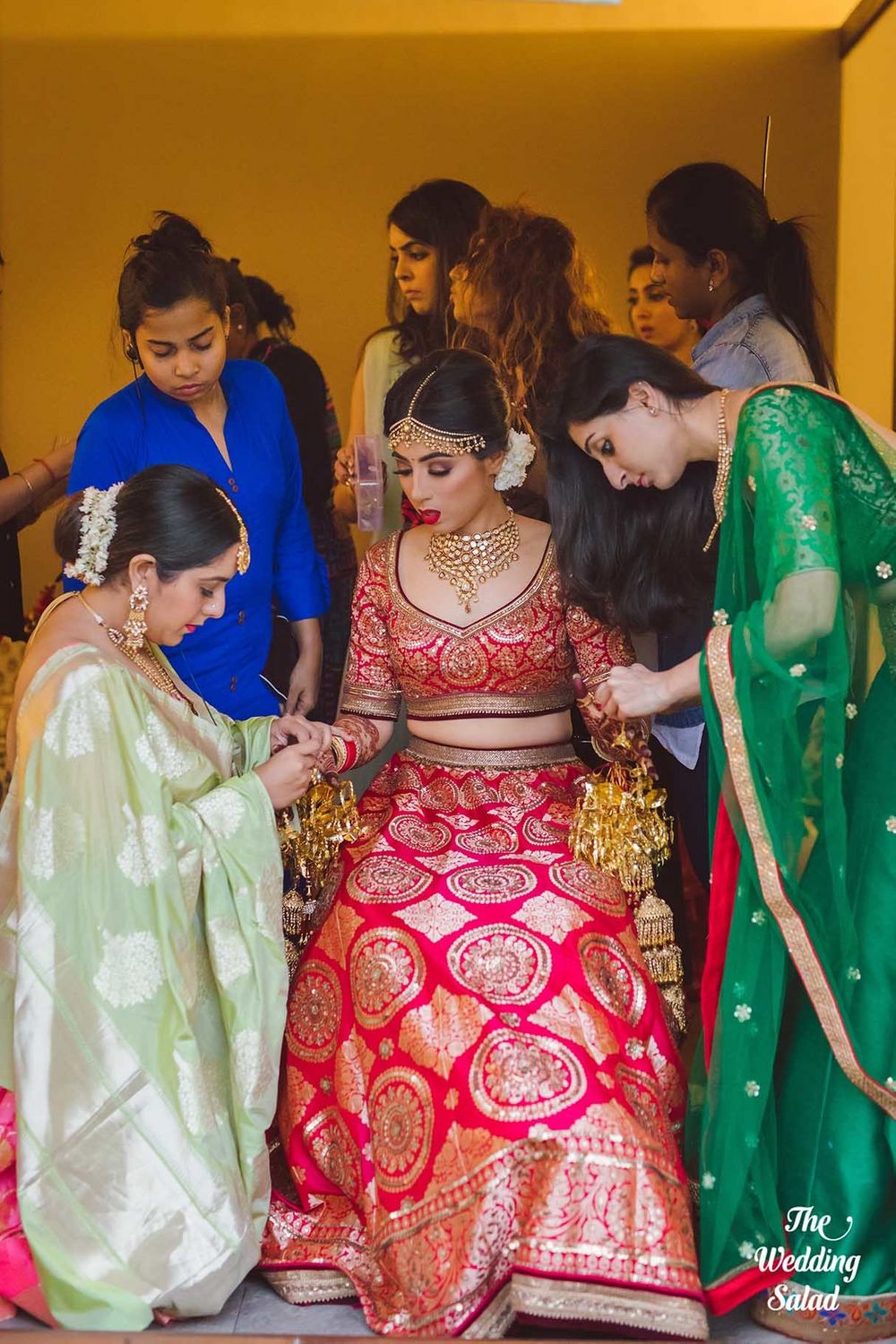 Photo of Bride with bridesmaids helping her get ready shot