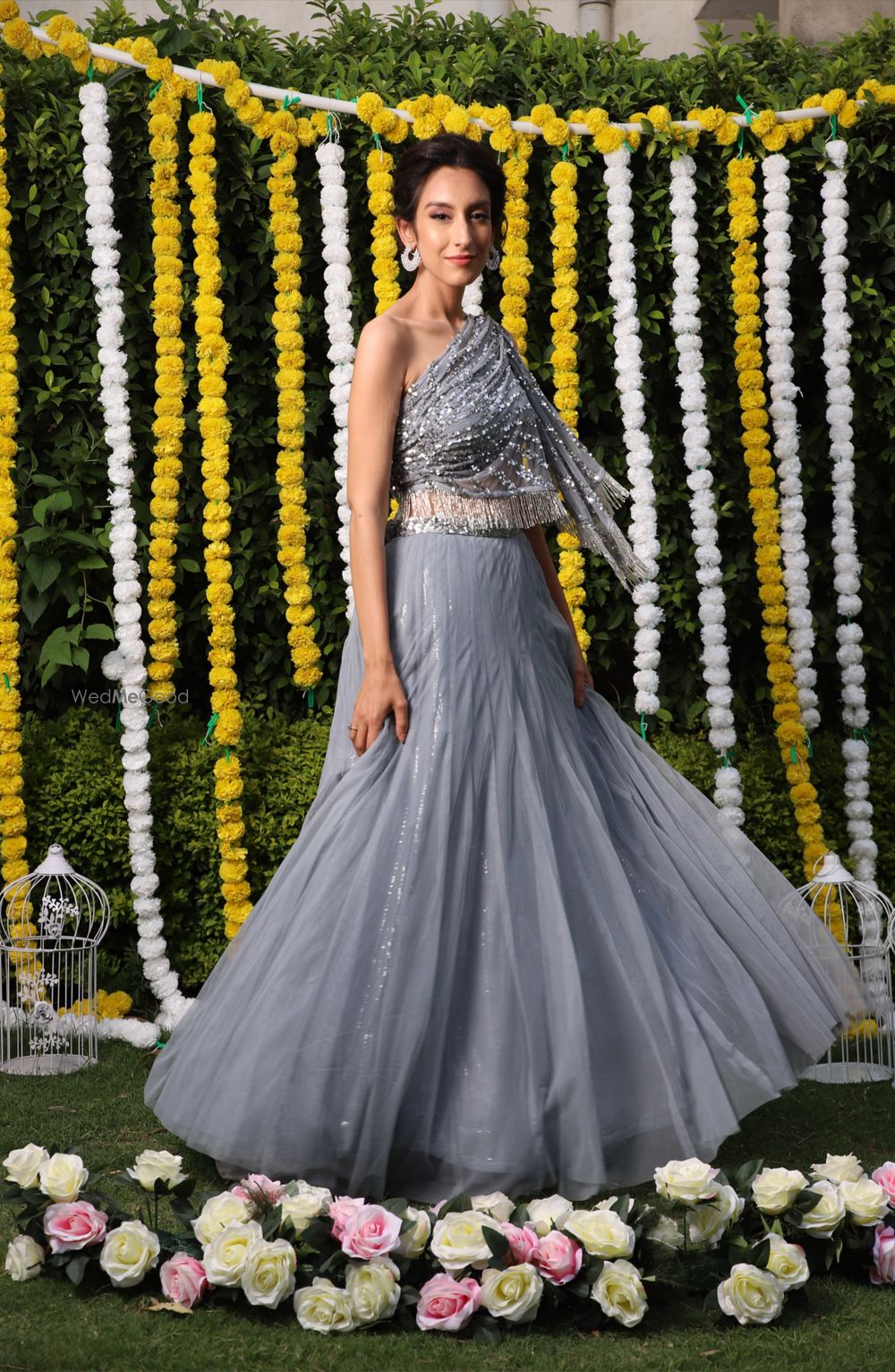 Photo of A bride-to-be in an off-shoulder blouse and skirt, twirling on her mehndi