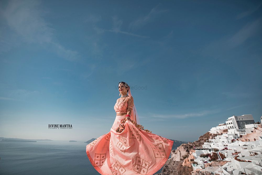 Photo of Twirling bride in peach lehenga Santorini