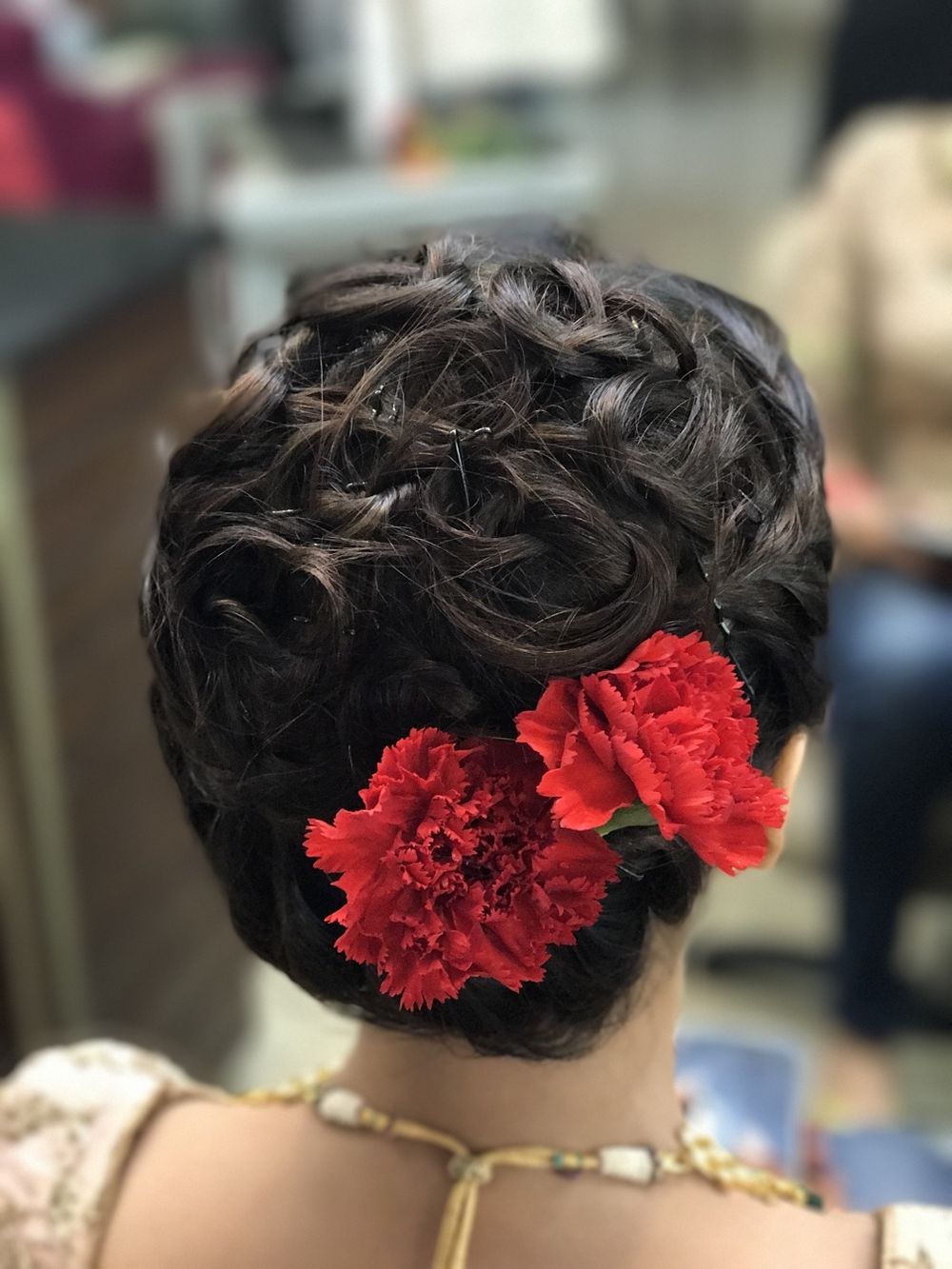 Photo of Curly bun with red carnations for bride