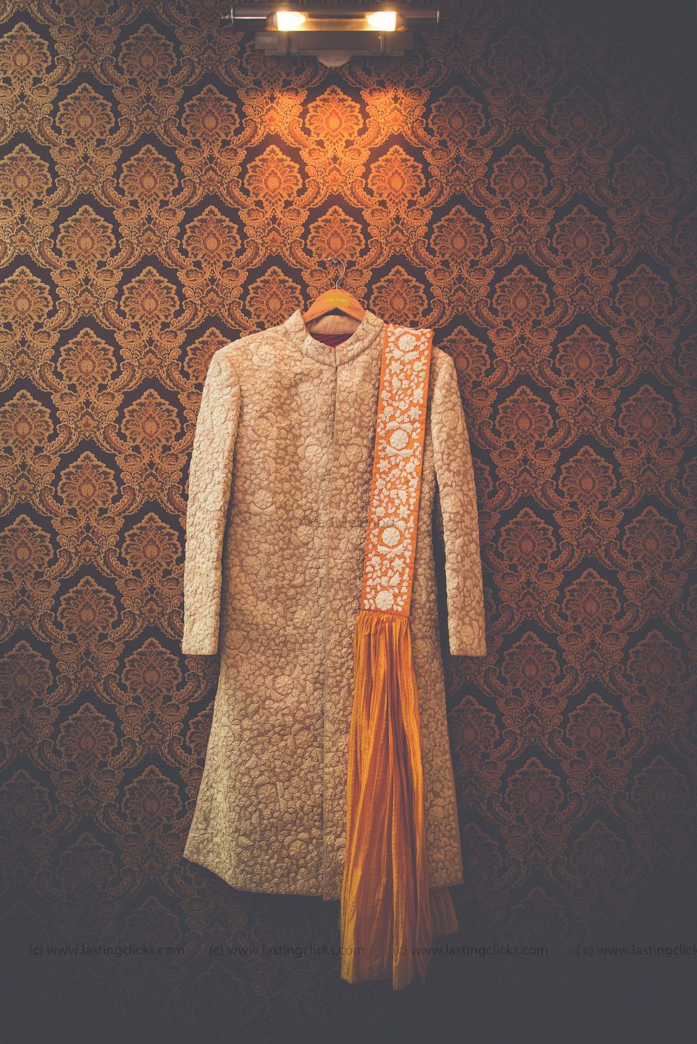 Photo of off white and orange sherwani