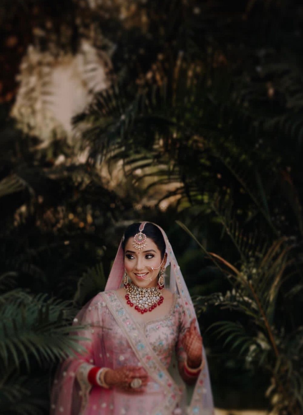 Photo of Bride in pink lehenga with red jewellery