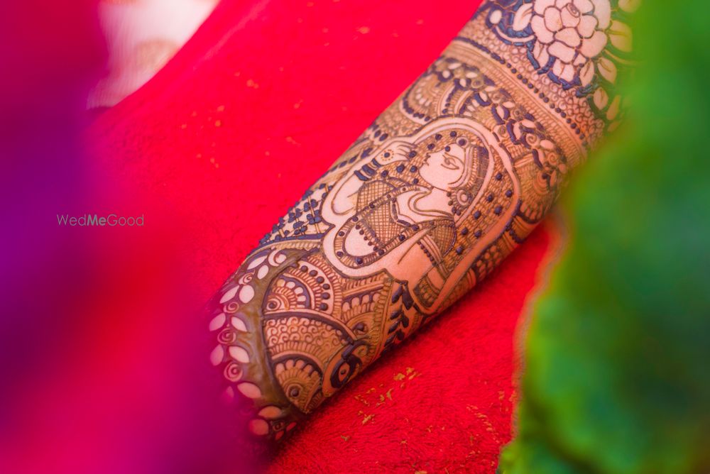 Photo of Mehendi with bridal portrait on arm