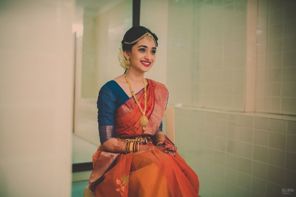 Photo of South Indian Bride in Orange and Peacock Blue Saree