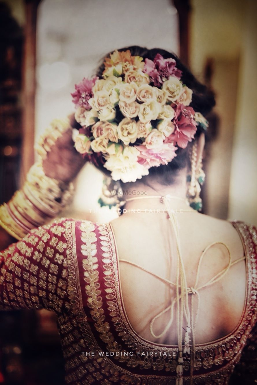 Photo of Bridal bun with loads of small flowers