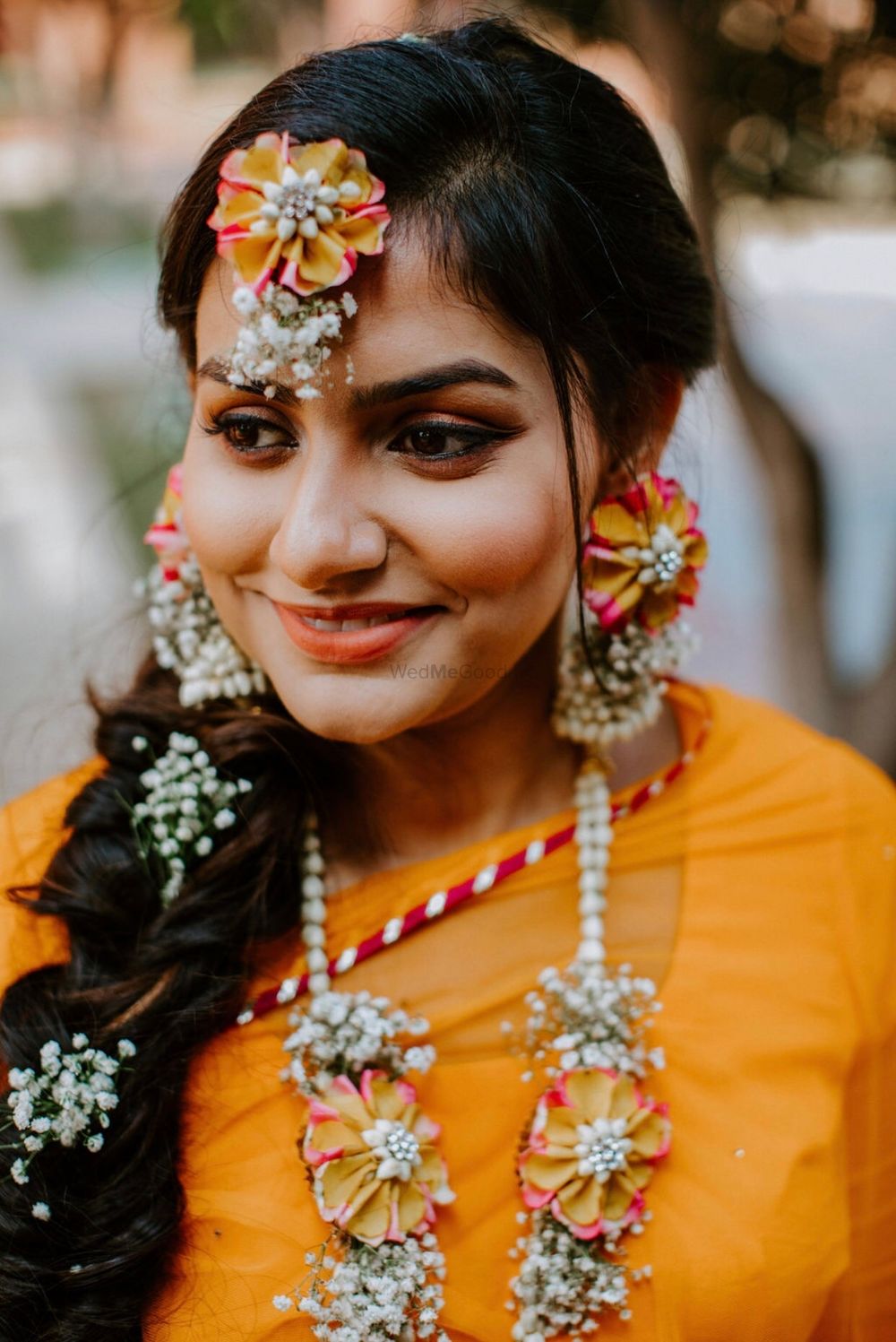 Photo of A bride to be in dry floral jewelry for her mehndi