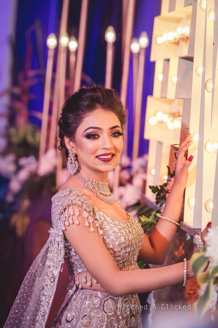Photo of Bridal makeup with silver lehenga and tassels on sleeves