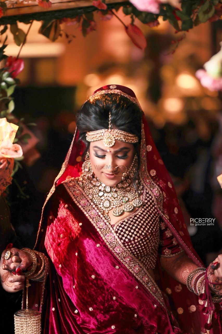 Photo of Winter bride wearing maroon velvet lehenga