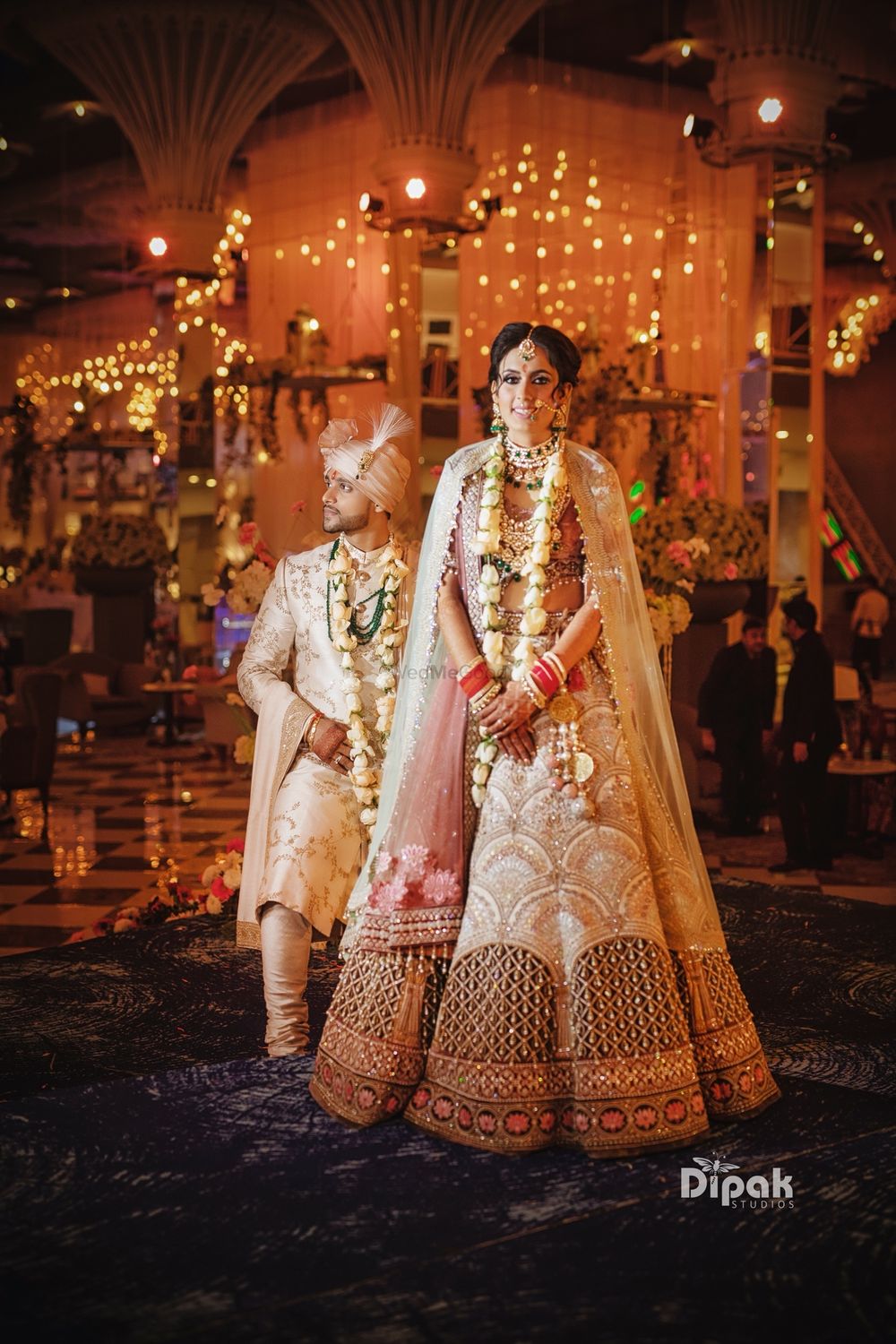 Photo of Bride and groom shot with pastel jaimala and unique lehenga