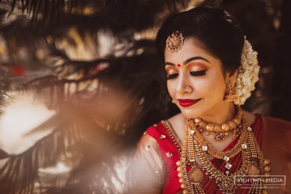 Photo of A south Indian bride with temlpe jewelery wearing nude makeup and flowers in her hair