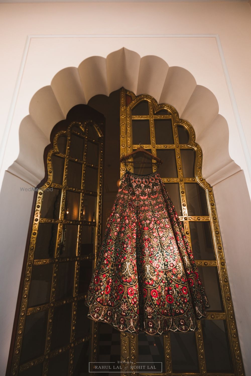 Photo of Unique bridal lehenga on hanger over the window