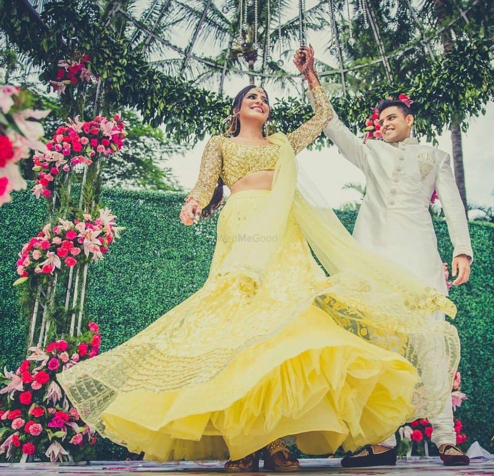 Photo of Groom and bride twirl shot idea with yellow lehenga