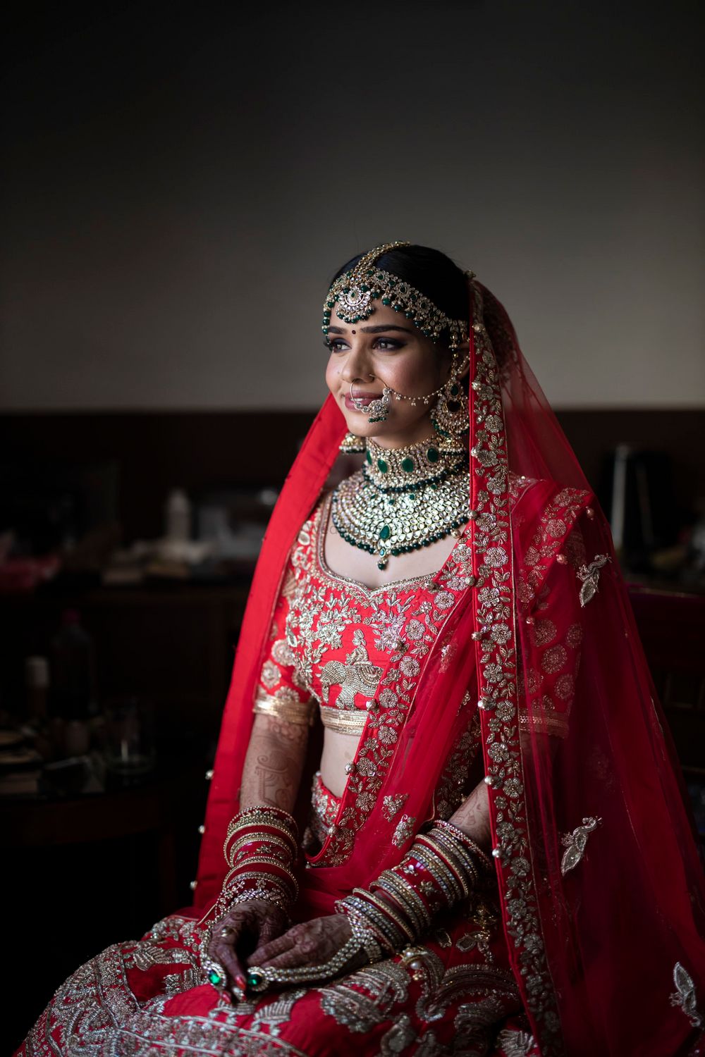 Photo of North Indian bride in red lehenga and contrasting jewellery