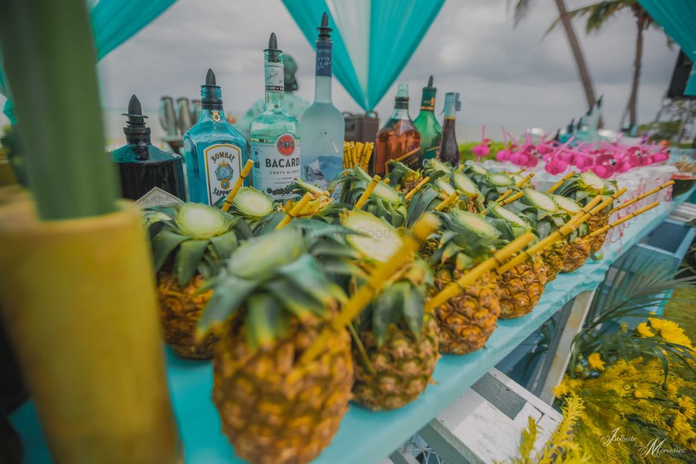 Photo of Pool party bar idea with drinks in pineapples