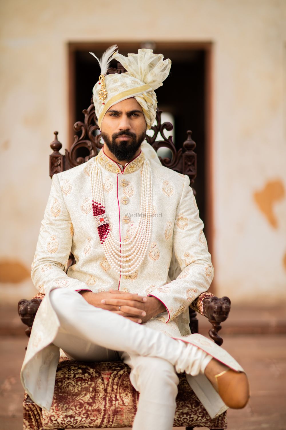 Photo of A groom in off white and gold sherwani with a matching safa