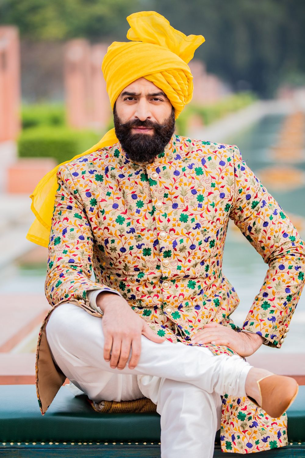 Photo of A groom in floral sherwani paired with yellow safa