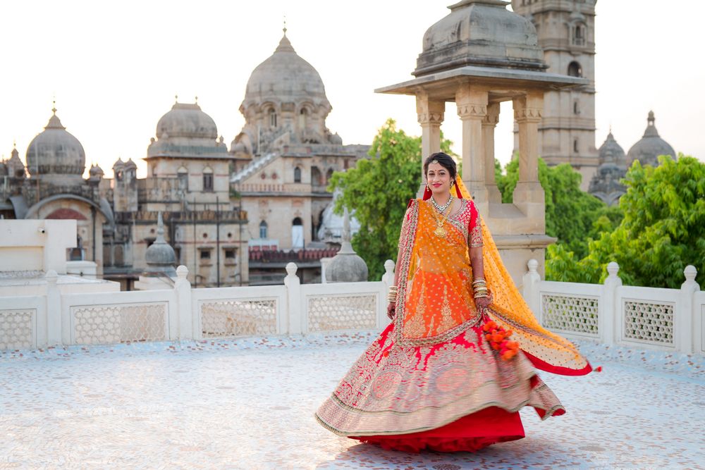Photo of Red and Gold Twirling Lehenga with Orange Dupatta