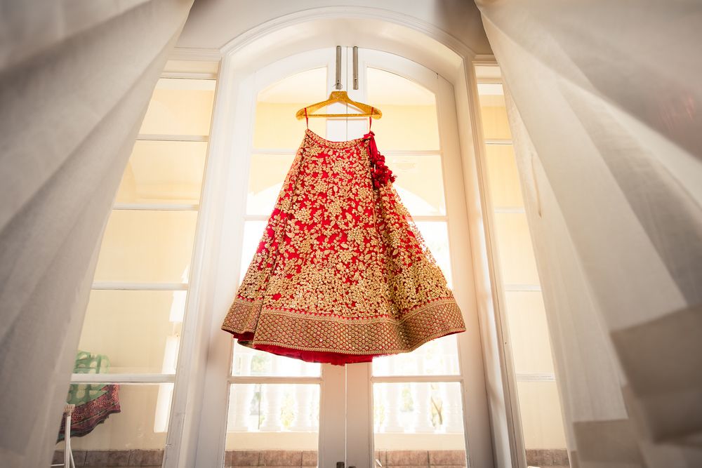 Photo of Red and gold lehenga on hanger