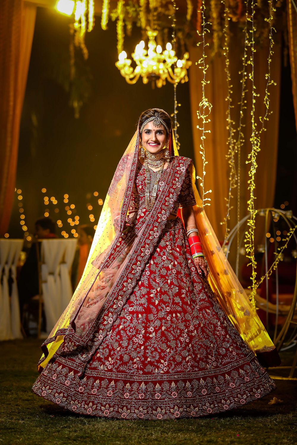 Photo of A pretty bride twirling in her beautiful red lehenga.
