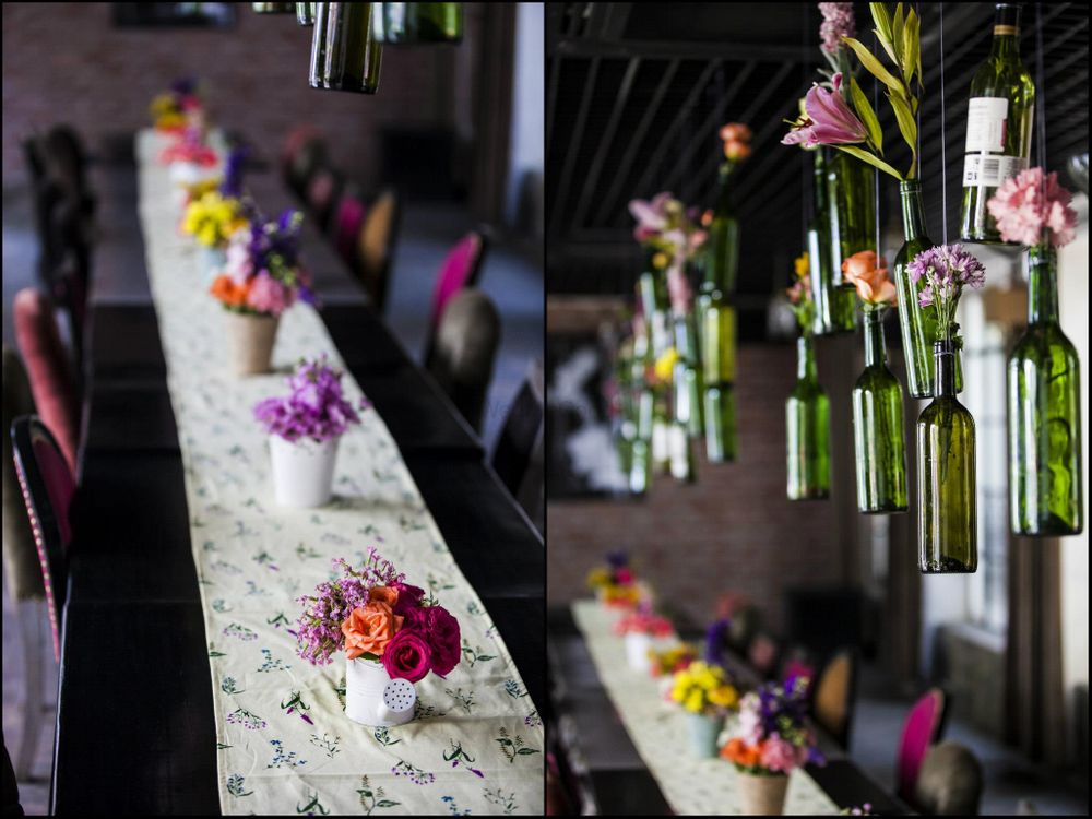 Photo of bottles with flowers hanging from ceiling over table