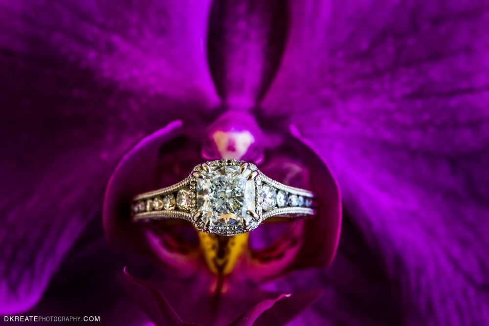 Photo of engagement ring on a purple flower