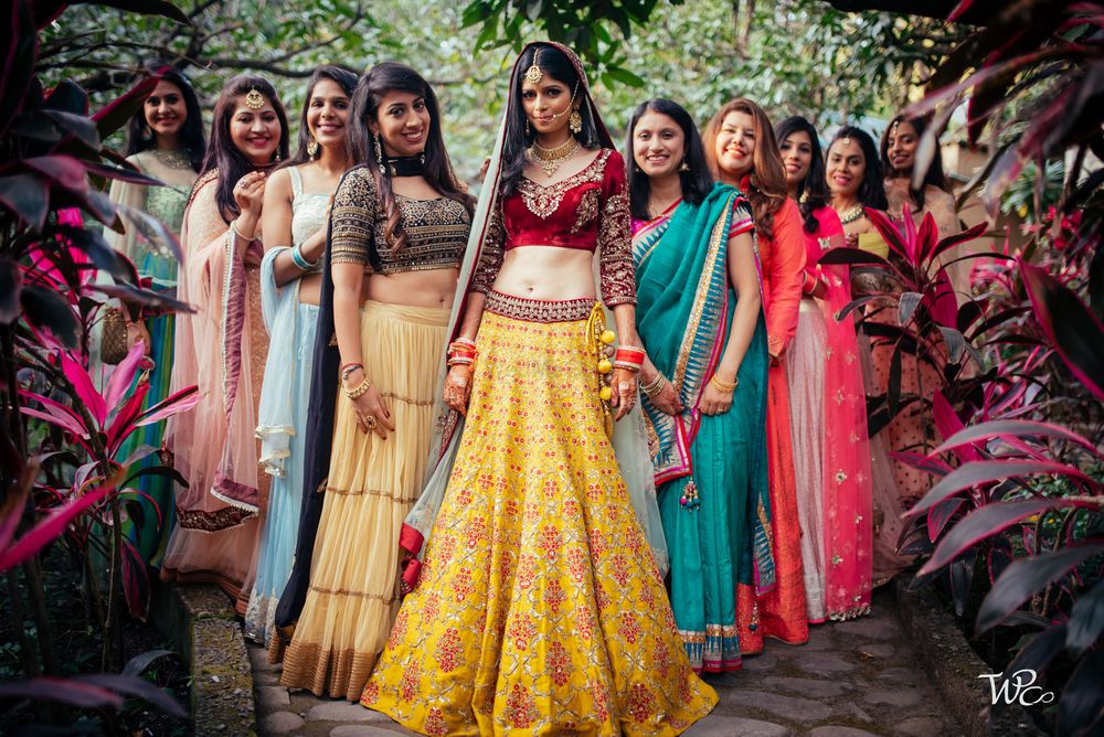 Photo of A bride stands tall with her bridesmaids