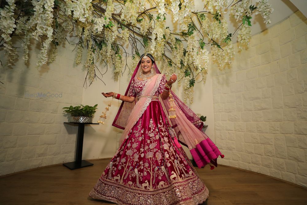 Photo of A happy bridal shot twirling in her beautiful wine coloured lehenga.