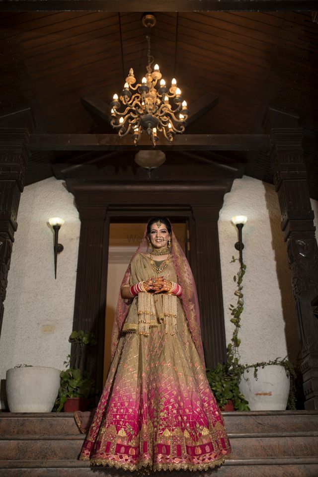 Photo of A beautiful bride in gold lehenga with a subtle mix of pink ombre in it.