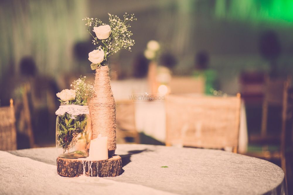 Photo of Burlap Bottles with Floral Vase Table Centerpiece