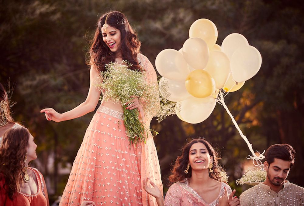 Photo of A bride in a shimmer, sequined lehenga with her bridesmaids