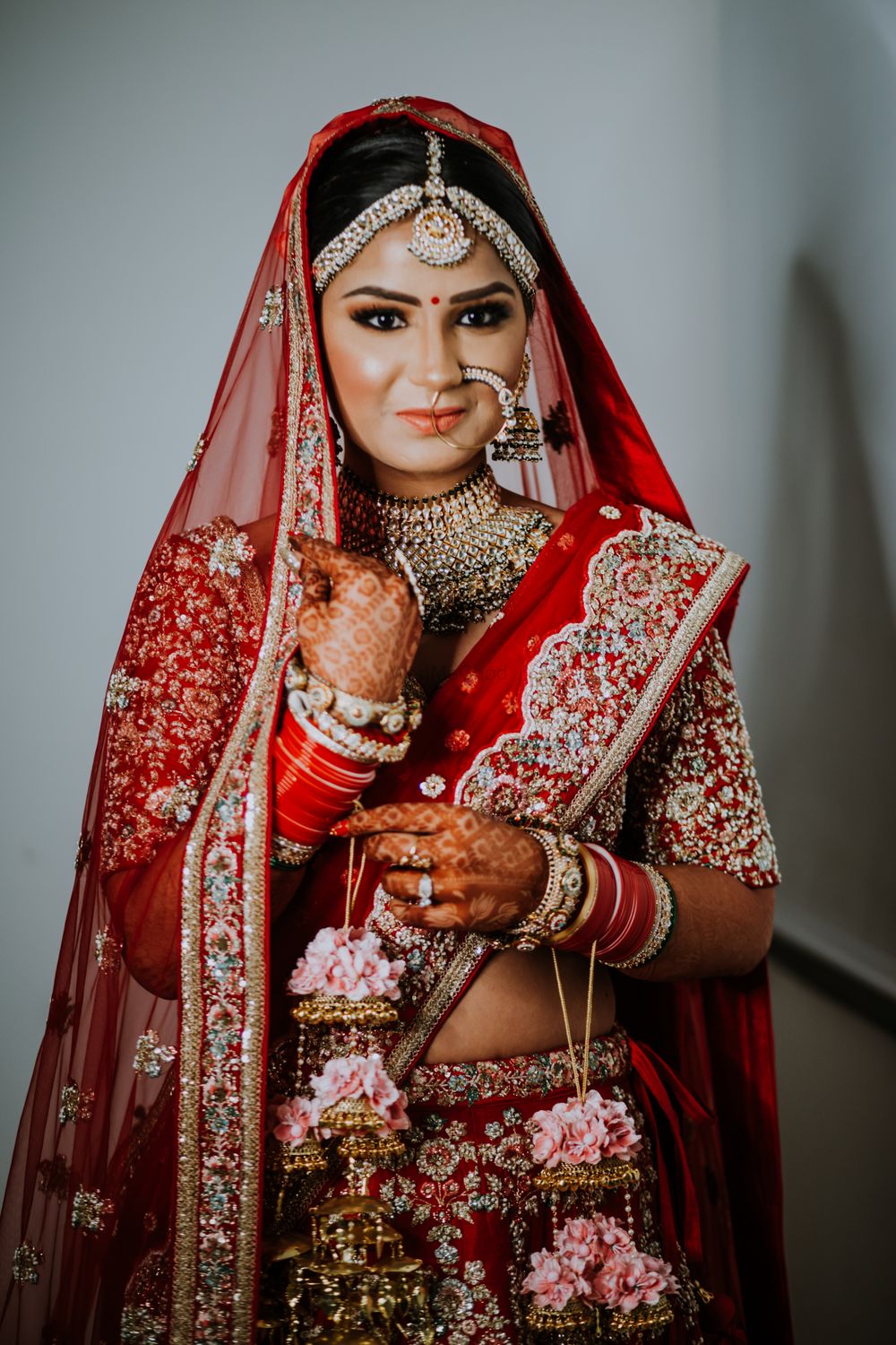 Photo of Bride in red with dry pink floral kaleere