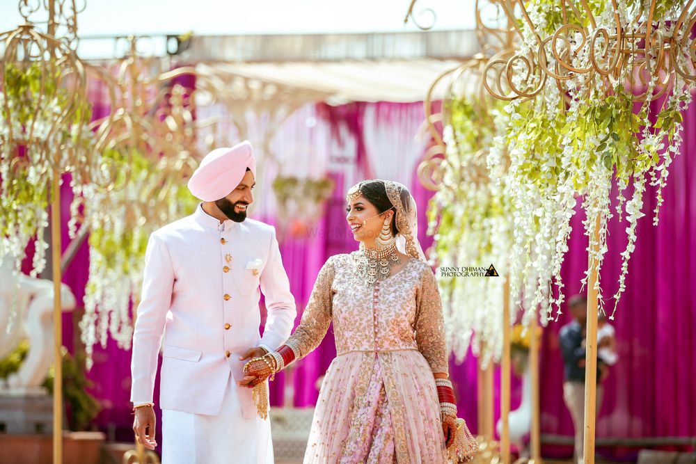 Photo of Coordinated sikh bride and groom wearing light pink outfits