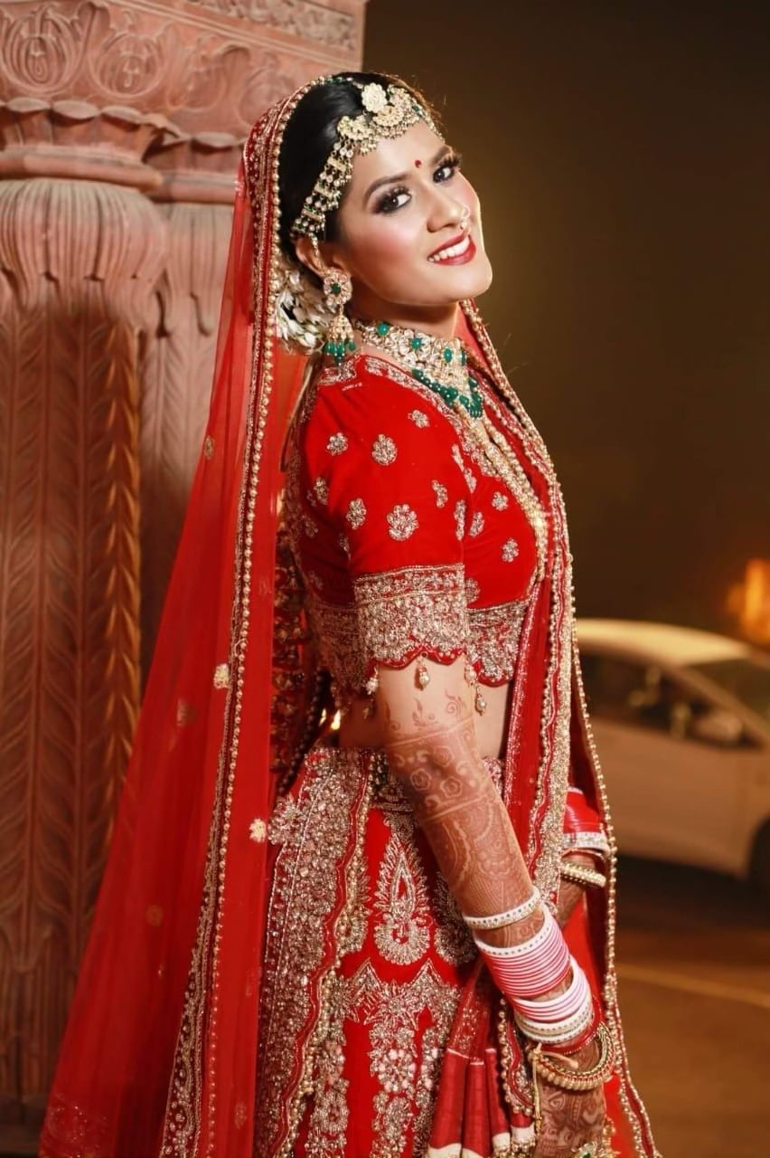 Photo of A beautiful bride on her wedding in a stunning red bridal lehenga and subtle makeup.