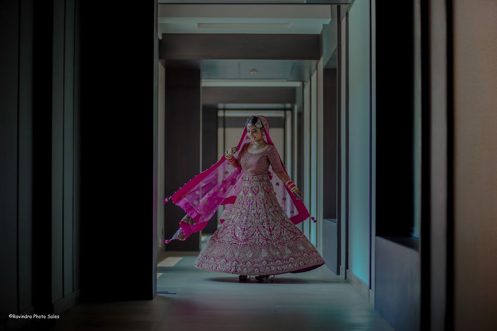 Photo of Twirling bridal shot in a stunning bright pink lehenga.