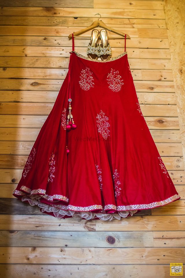 Photo of Red Lehenga and Gold Shoes on a Hanger