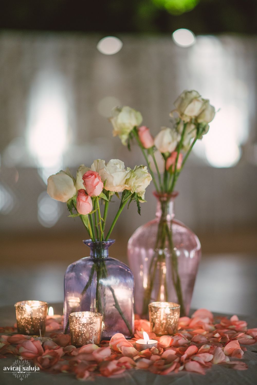 Photo of Glass Bottles with Roses Decor and Candles