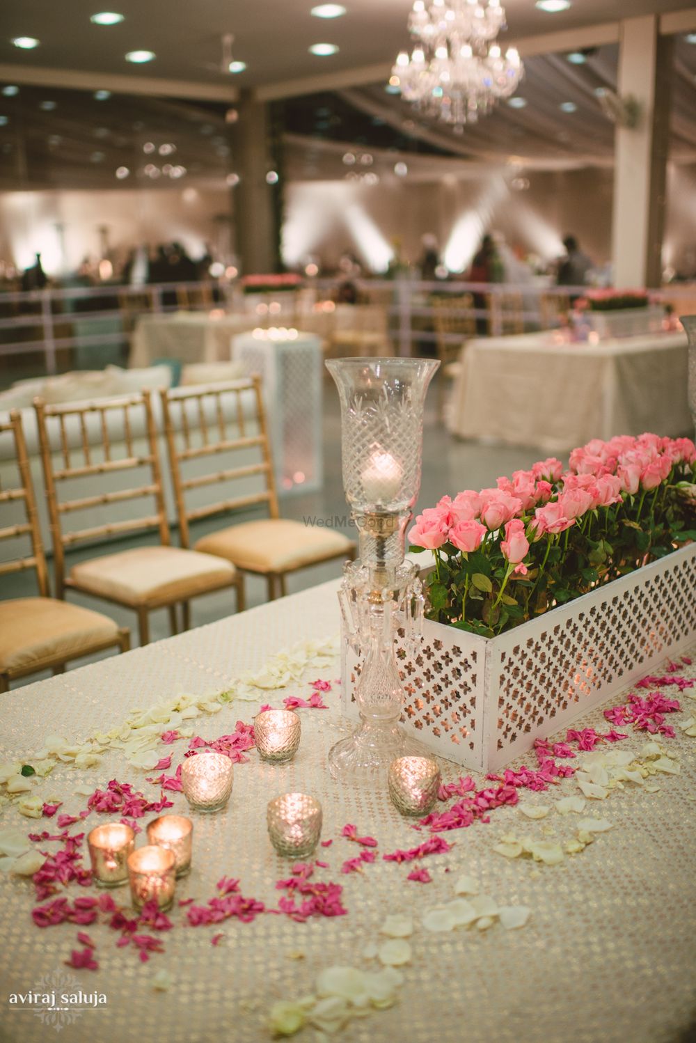 Photo of Table centerpieces with pink roses and  glass
