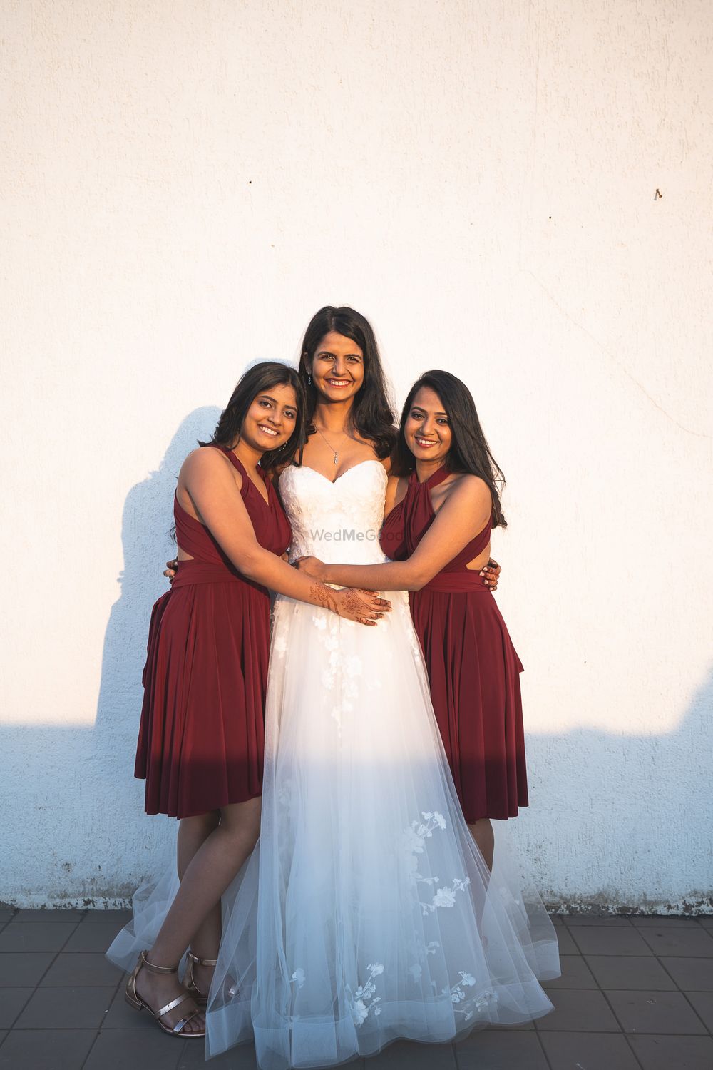 Photo of A bride with her bridesmaid in matching bridesmaid dresses.