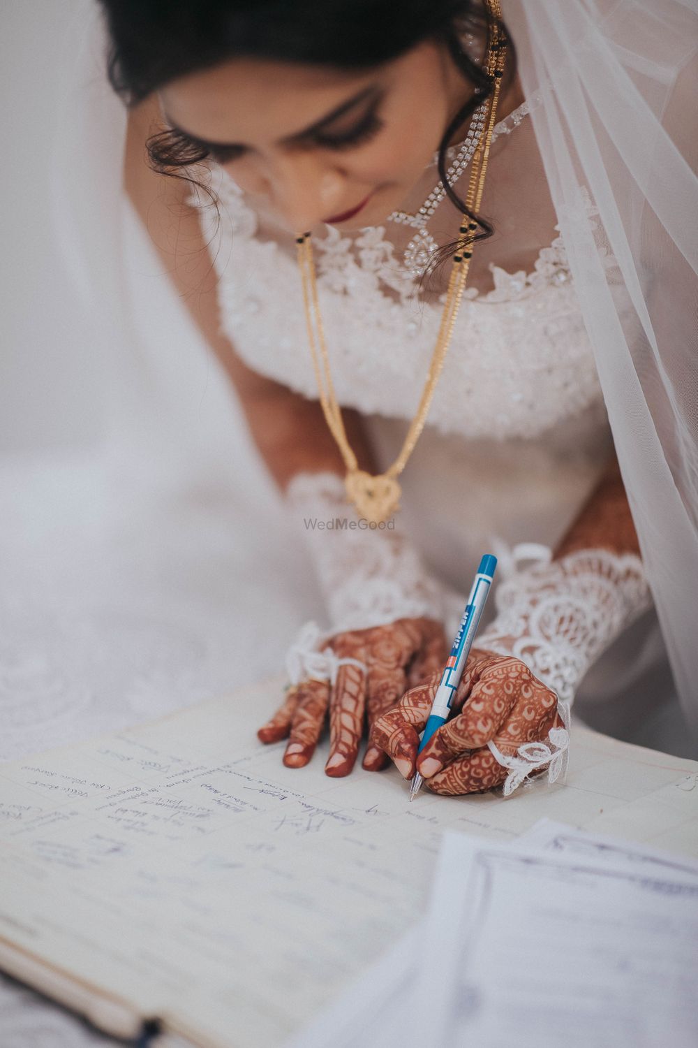 Photo of Bride signing papers during christian wedding