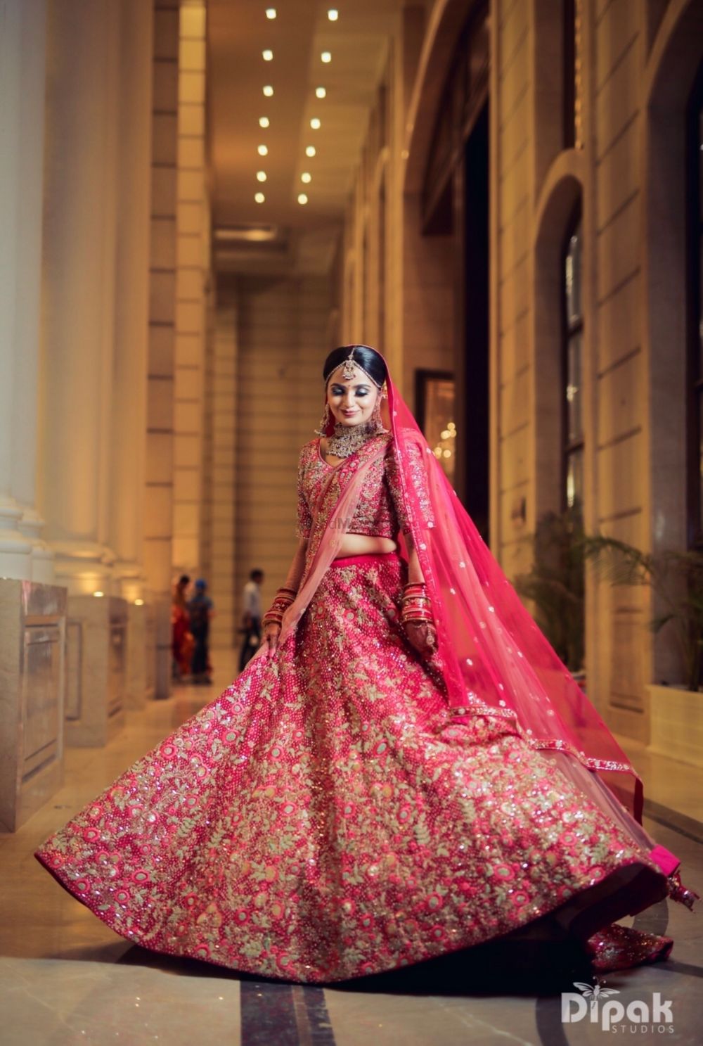 Photo of Twirling bride shot in a red and gold lehenga