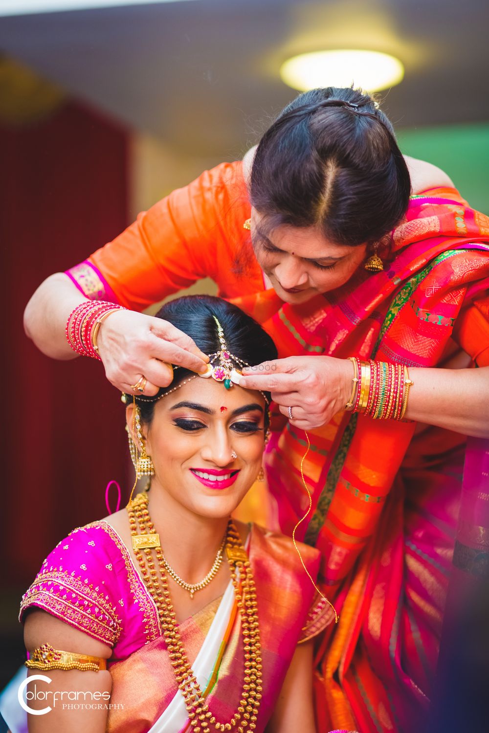 Photo of Mother of the bride adjusting the brides maang tikka