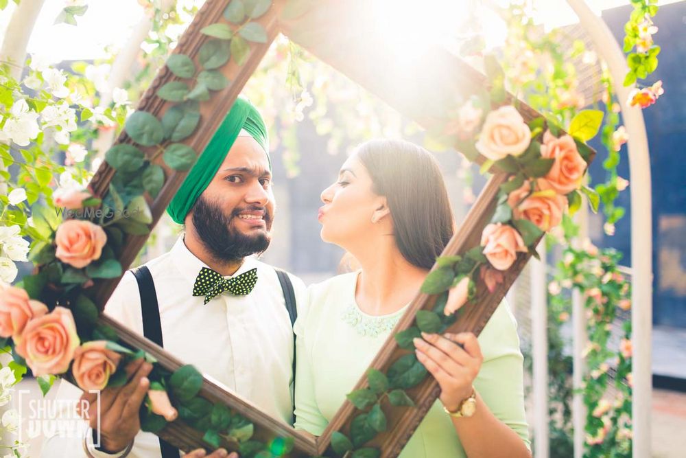 Photo of Wooden frame with bride and groom peeping through