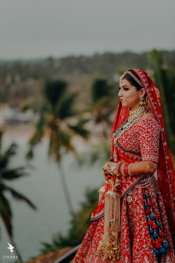 Photo of red and blue bridal lehenga with unique latkans