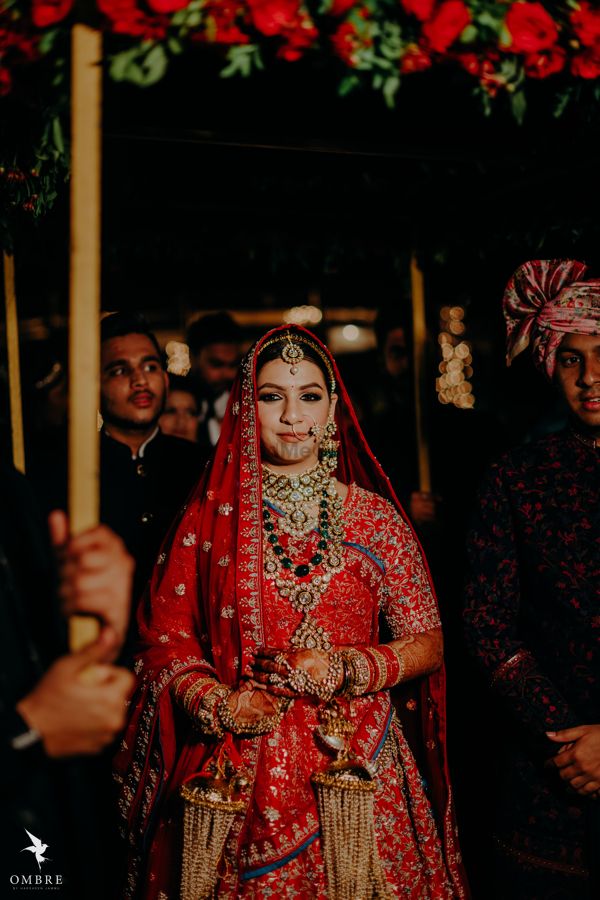 Photo of bridal entry portrait wearing green jewellery with red lehenga