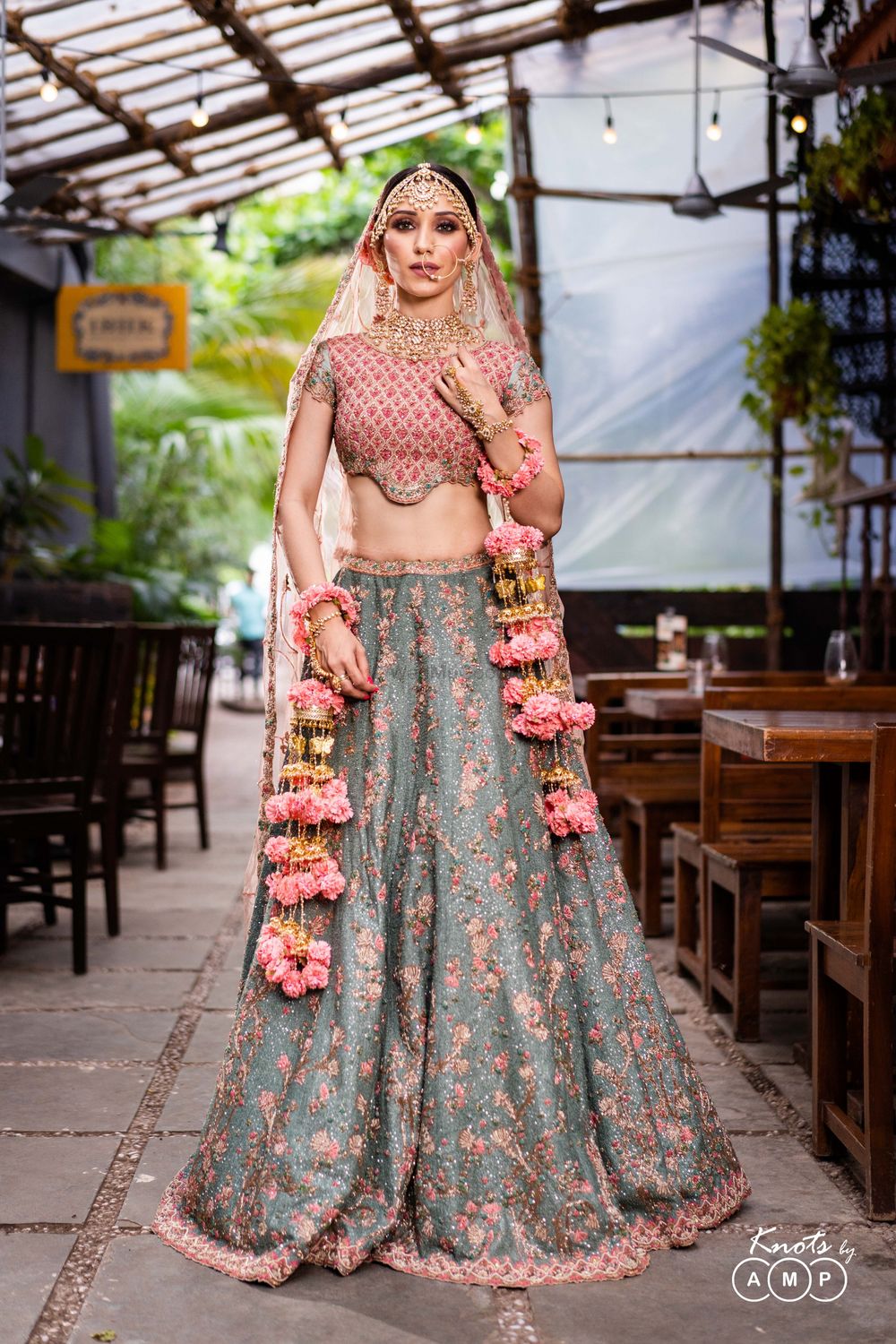 Photo of A beautiful bride in a stunning embroidered lehenga with light pink choli and ash grey lehenga skirt.